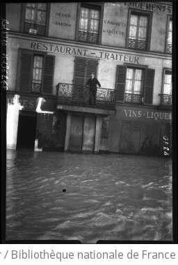 Inondations, 24 janvier 1910, quai de Passy [Paris, 16e arrondissement, personne sur un balcon surplombant l eau de la crue] : [photographie de presse] / [Agence Rol]