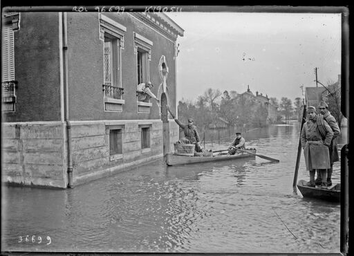 Châlons[-en-Champagne,] 5/11/24, [inondations,] rue de Constantine, distribution de pain [en barque] : [photographie de presse] / [Agence Rol]