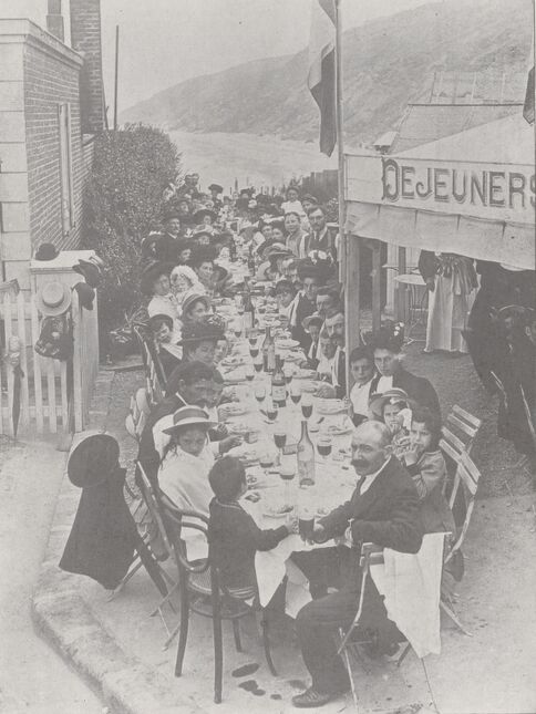 Excursion de familles ouvrières à Trouville-sur-Mer, offerte par le journal Le Lexovien. Un déjeuner de 130 couverts au restaurant de la Jetée-promenade. Image publiée à Lisieux en octobre 1910 dans le journal : La Revue illustrée du Calvados